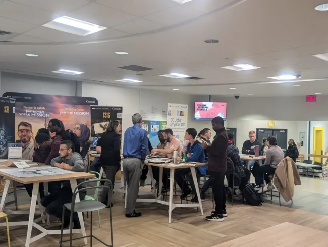 Les participants assis aux différents tables durant l'activité.