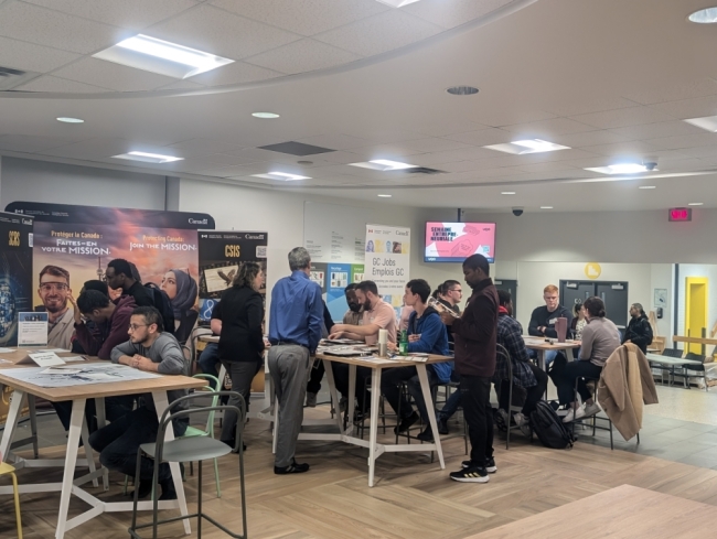Les participants assis aux différents tables durant l'activité.