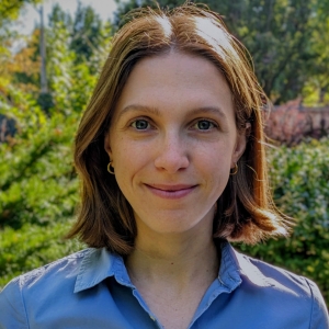 Photo de profil de Natalia Ladyka-Wojcik, vêtue d'une chemise bleue sur fond vert.